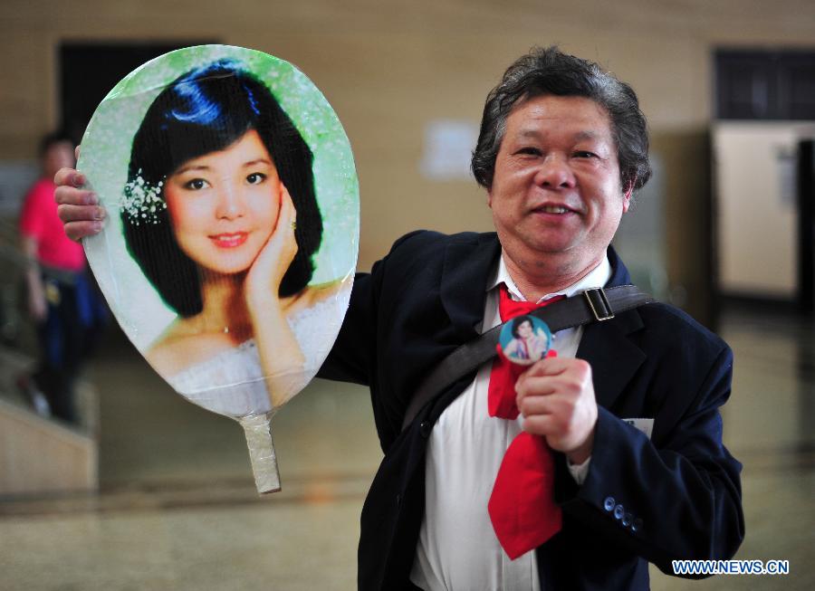 A fan shows a picture of singer Teresa Teng during a special exhibition themed in Teng, at the Hubei provincial museum in Wuhan, capital of central China&apos;s Hubei Province, March 28, 2014.