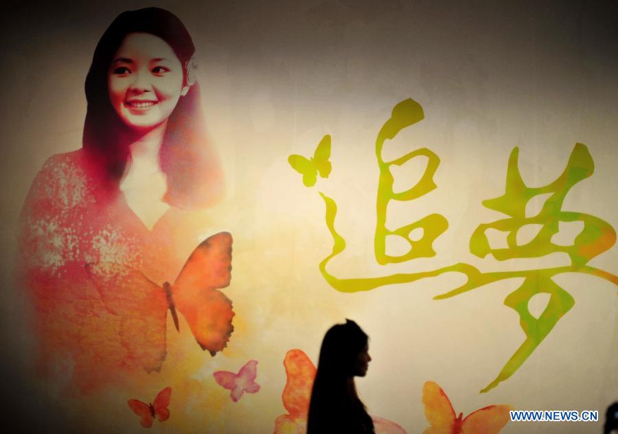 A visitor walks past a picture of singer Teresa Teng during a special exhibition themed in Teng, at the Hubei provincial museum in Wuhan, capital of central China&apos;s Hubei Province, March 28, 2014. 