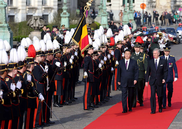 President Xi Jinping, accompanied by Belgian King Philippe, reviews the honour guard at a ceremony in Brussels on Sunday. [Photo/China Daily via agencies]