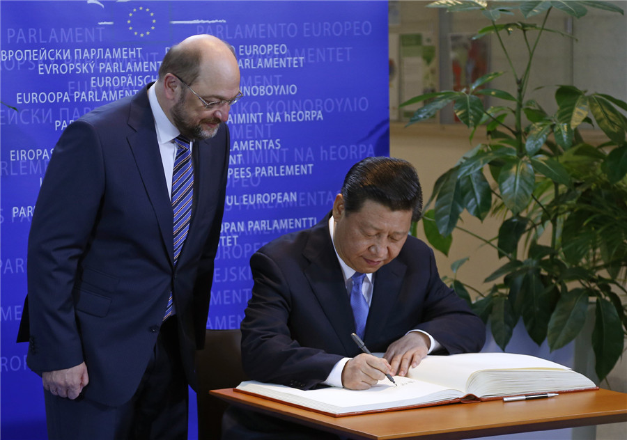 Chinese President Xi Jinping (R) signs a guest book next to European Parliament President Martin Schulz at the European Parliament in Brussels March 31, 2014. [Photo/China Daily via agencies] 
