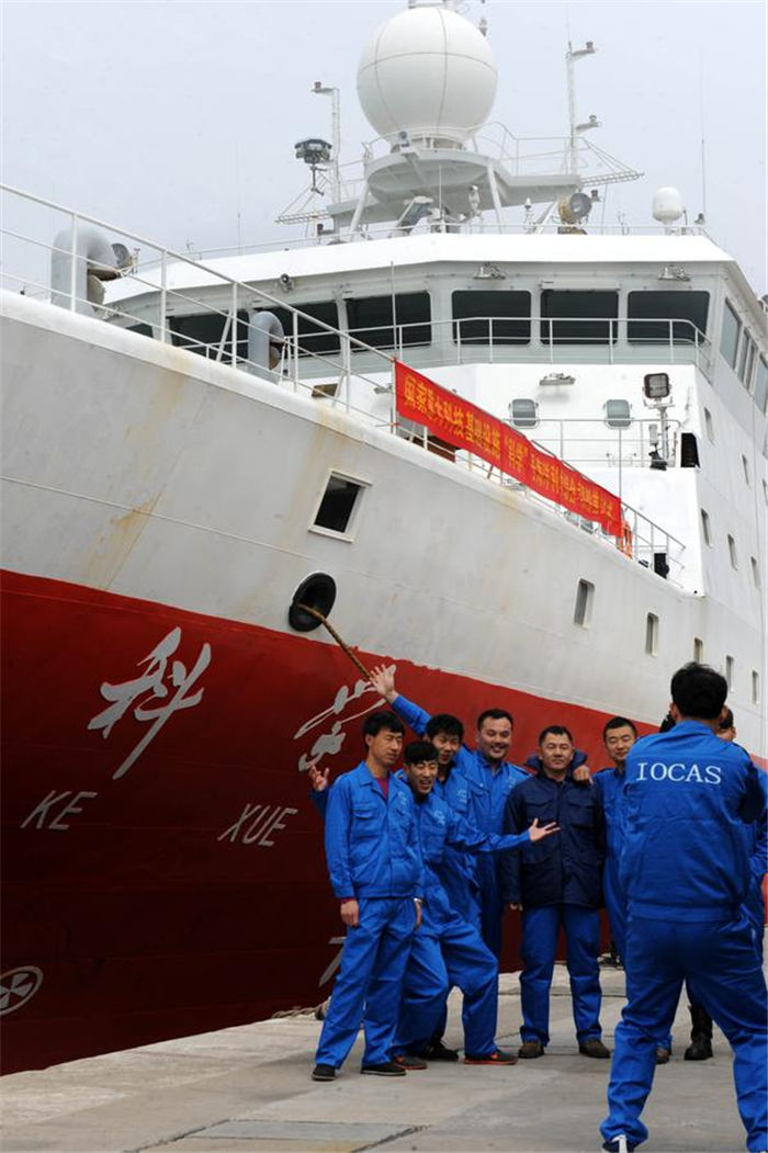 Scientists and technicians on board the research vessel Kexue take a picture before embarking on their research mission in the western Pacific on Tuesday, at Zhongyuan port, Qingdao, East China's Shandong province. [Photo/Xinhua]