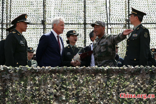 U.S. Secretary of Defense Chuck Hagel (2L) listens to a student as he watches an engineering equipment training demostration at China Military Academy during a tour in Changping District of Beijing on April 9, 2014. [Photo: CFP]