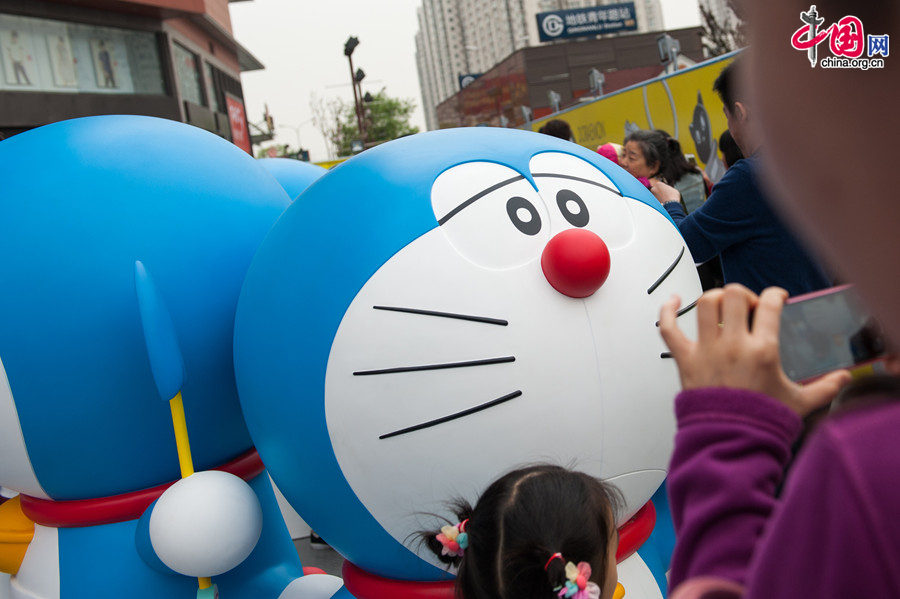 A &apos;100 Doraemon Secret Gadgets Expo&apos; is launched at Joycity Shopping Center in Beijing, on Saturday, April 19, 2014. The exhibition will last until June 22. A hundred life-size Doraemon figures, each of which bearing a distinct secret gadget, will be displayed during the show. Doraemon, a 22nd-century robotic cat, has been a popular anime character since its introduction by Japanese cartoonist Fujiko Fujio in 1969. [Photo by Chen Boyuan / China.org.cn]