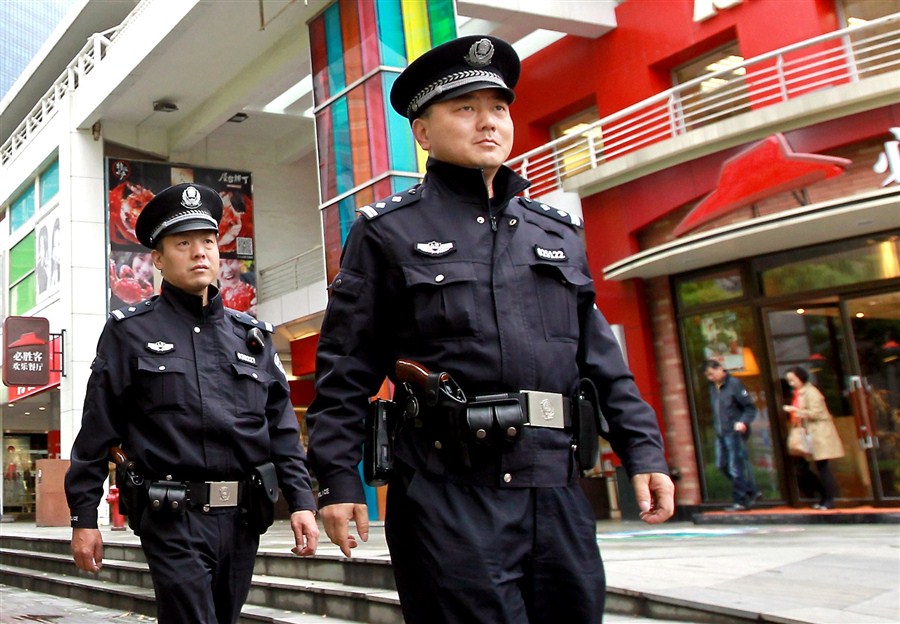 Two officers armed with revolvers are seen in Shanghai yesterday, the first day when more than 1,000 members of the city's police force were allowed to carry guns on routine patrol.[Photo/Xinhua]