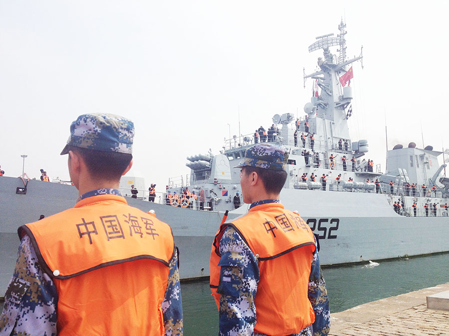 Chinese naval officers guard Pakistan's frigate Shamsheer, which arrived in Qingdao, East China's Shandong province, April 20, ahead of the 14th annual meeting of the Western Pacific Naval Symposium (WPNS), which the PLA's navy is expected to launch on April 22. [Photo/China Daily]