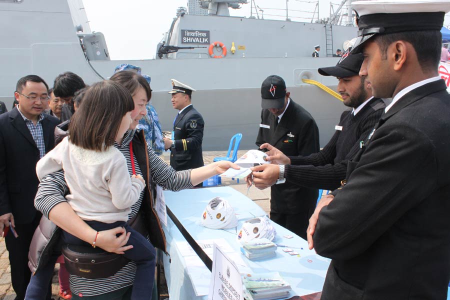 Crew members of an Indian navy ship hand out souvenirs and various leaflets to visitors at an activity linked to the 14th annual meeting of the Western Pacific Naval Symposium, in Qingdao, Shandong province, April 20. [Photo by Peng Yining/chinadaily.com.cn]