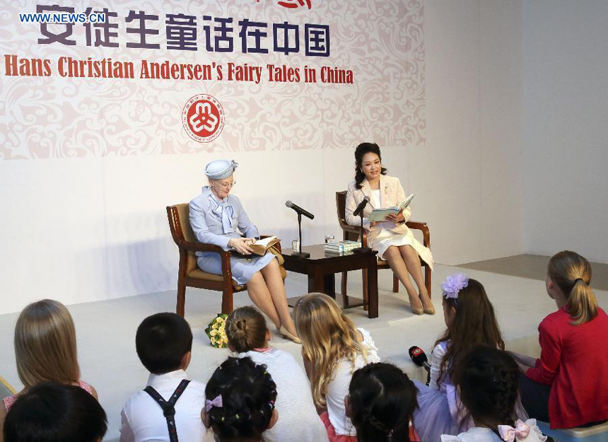 Chinese President Xi Jinping&apos;s wife, Peng Liyuan (R), and Danish Queen Margrethe II read a selection of &apos;the Ugly Duckling&apos; for kids in Beijing, capital of China, April 25, 2014. Queen of Denmark Margrethe II visited an exhibition on Hans Christian Andersen&apos;s fairy tales accompanied by Peng here on Friday.(