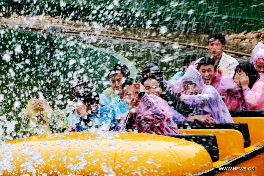 Tourists take a roller coaster at the Fantawild Adventure amusement park in Wuhu, east China&apos;s Anhui Province, April 28, 2014. Many people in Wuhu went to amusement parks to enjoy spring outdoors. 