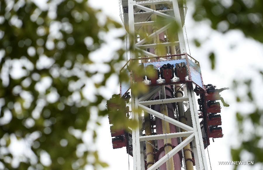 Tourists take a roller coaster at the Fantawild Dreamland amusement park, in Wuhu, east China&apos;s Anhui Province, April 28, 2014. Many people in Wuhu went to amusement parks to enjoy spring outdoors.