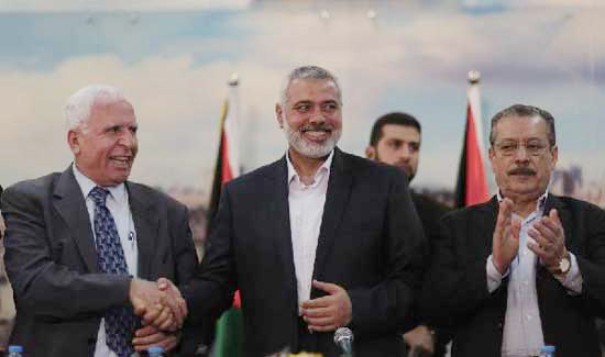 Palestinian Fatah delegation chief Azzam al-Ahmed (L), Prime Minister of Hamas authorities in the Gaza Strip Ismail Haniya (C) and secretary-general of the Palestinian Arab Front Jameel Shehadeh pose for a picture after a press conference in Gaza on April 23, 2014. [Xinhua photo]