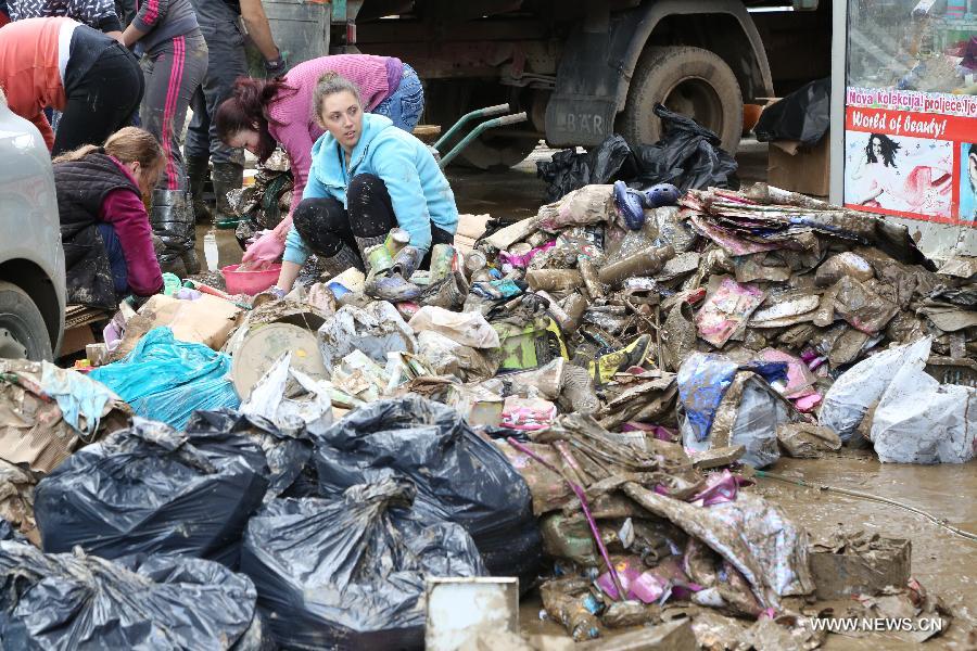 Local residents begin to clean their houses and streets in Maglaj, nearby Doboj, Bosnia-Herzegovina, on May 18, 2014. The flooding, the worst in about 120 years, killed at least 20 people, local media reported. [Photo/Xinhua]