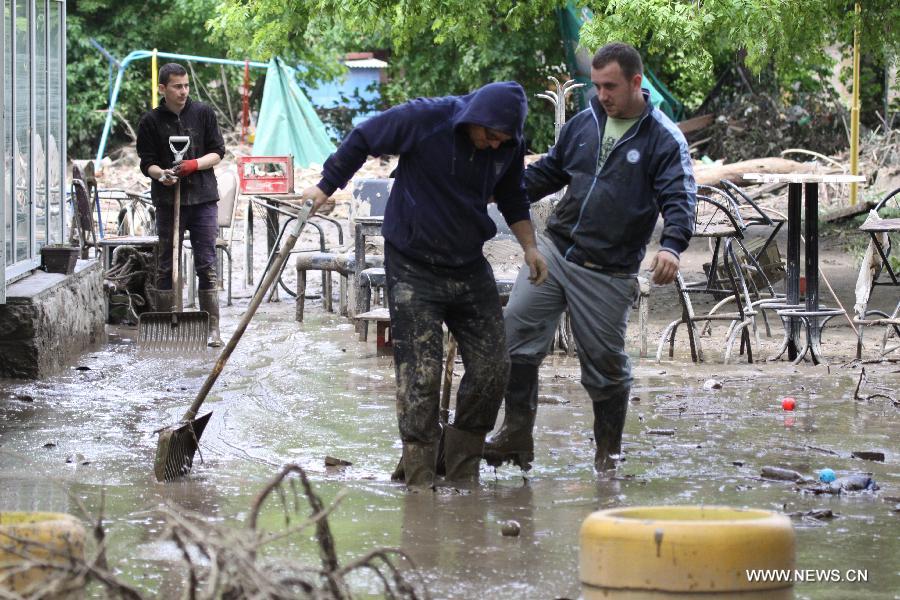 Local residents begin to clean their houses and streets in Maglaj, nearby Doboj, Bosnia-Herzegovina, on May 18, 2014. The flooding, the worst in about 120 years, killed at least 20 people, local media reported. [Photo/Xinhua]