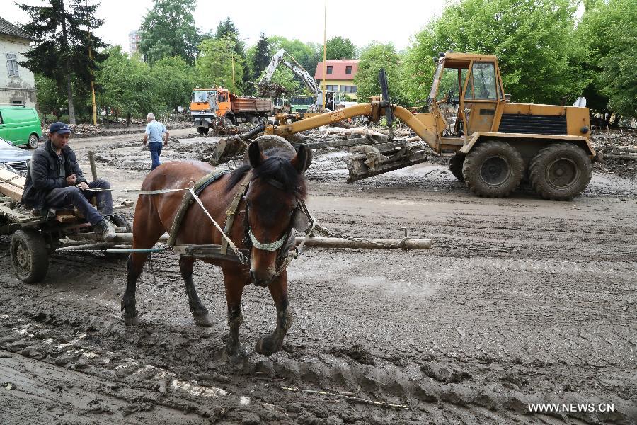 Local residents begin to clean their houses and streets in Maglaj, nearby Doboj, Bosnia-Herzegovina, on May 18, 2014. The flooding, the worst in about 120 years, killed at least 20 people, local media reported. [PhotoXinhua]