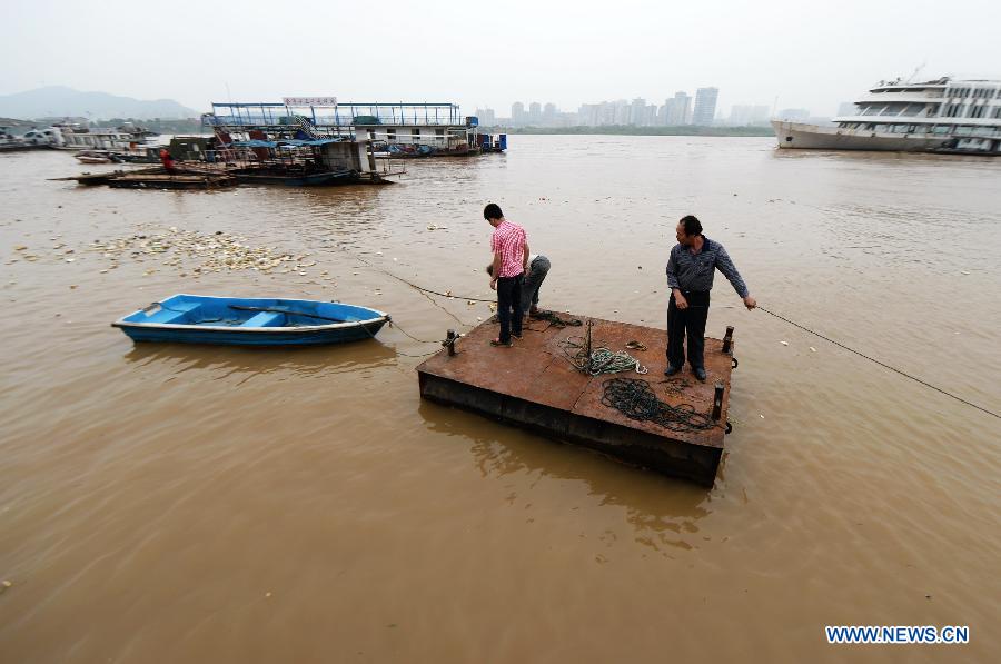 Boat owners try to resume the access to the bank at a flooded river port in Changsha, capital of central China's Hunan Province, May 26, 2014. Hunan issued the red alert of floods on May 25 as continuous downpours hit many parts of the province. A total of 400,000 people were affected and 16,776 displaced with the collapse of 520 houses. [Photo/Xinhua]