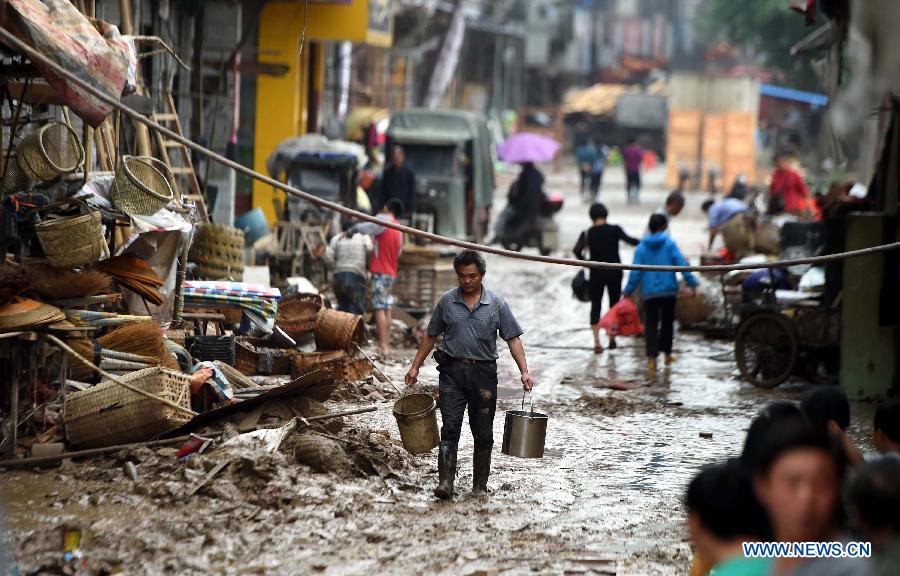 A man walks on a muddy road after a flood withdrew in Chenjiafang Town, Shaoyang County, central China's Hunan Province, May 26, 2014. Hunan issued the red alert of floods on May 25 as continuous downpours hit many parts of the province. A total of 400,000 people were affected and 16,776 displaced with the collapse of 520 houses. [Photo/Xinhua]