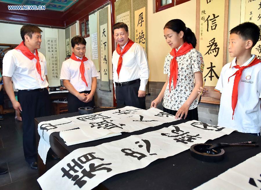 Chinese President Xi Jinping views pupils&apos; calligraphy works during his visit at Beijing Haidian National Primary School in Beijing, capital of China, May 30, 2014. Xi attended an activity to celebrate the upcoming International Children&apos;s Day at the primary school.