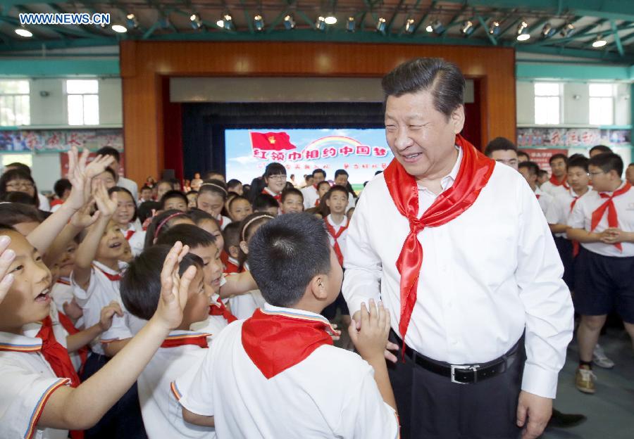 Chinese President Xi Jinping attends an initiation ceremony of Young Pioneers during his visit at Beijing Haidian National Primary School in Beijing, capital of China, May 30, 2014. Xi attended an activity to celebrate the upcoming International Children&apos;s Day at the primary school. 