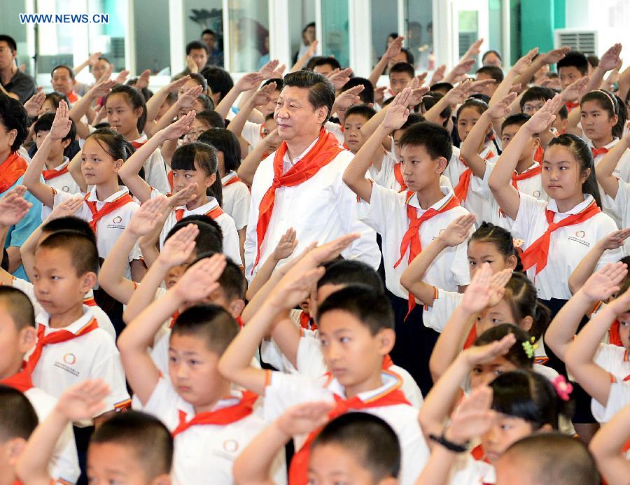 Chinese President Xi Jinping attends an initiation ceremony of Young Pioneers during his visit at Beijing Haidian National Primary School in Beijing, capital of China, May 30, 2014. Xi attended an activity to celebrate the upcoming International Children&apos;s Day at the primary school.