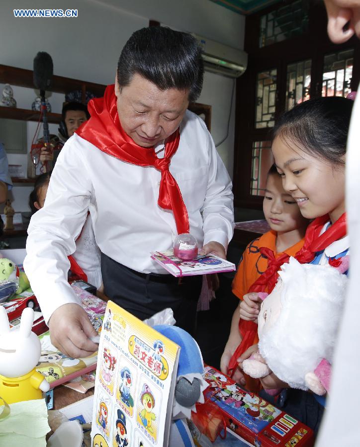 Chinese President Xi Jinping takes part in a charity sale activity with children during his visit at Beijing Haidian National Primary School in Beijing, capital of China, May 30, 2014. Xi attended an activity to celebrate the upcoming International Children&apos;s Day at the primary school. 