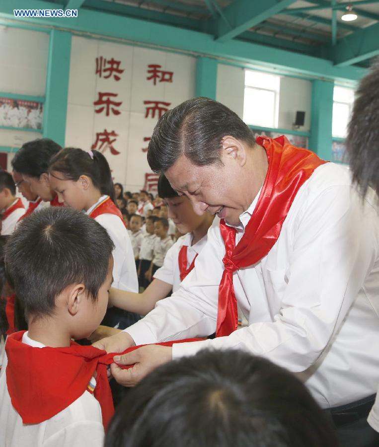 Chinese President Xi Jinping attends an initiation ceremony of Young Pioneers during his visit at Beijing Haidian National Primary School in Beijing, capital of China, May 30, 2014. Xi attended an activity to celebrate the upcoming International Children&apos;s Day at the primary school. 