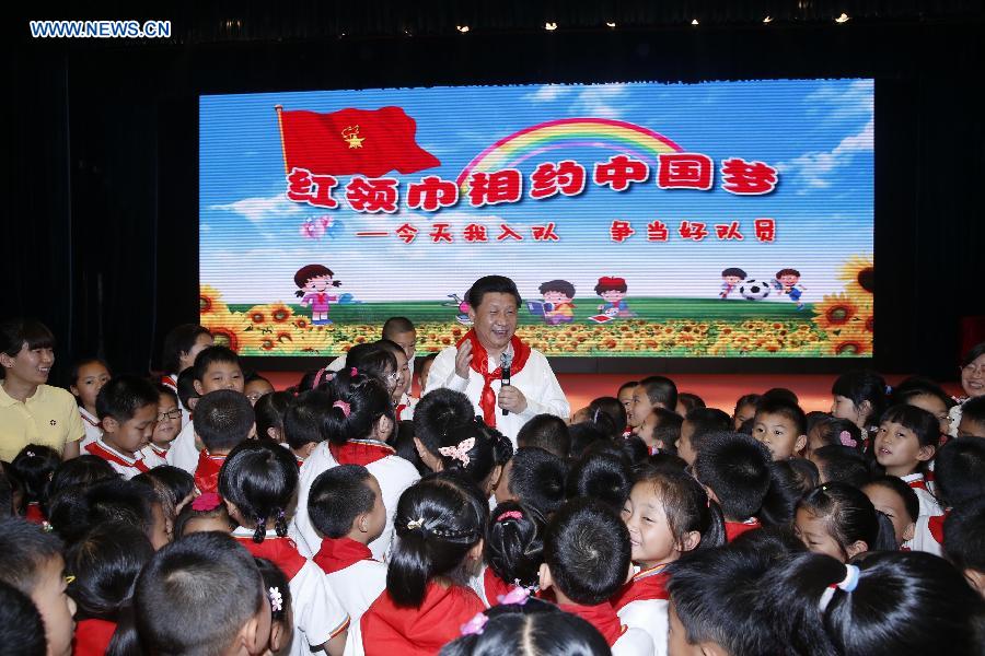 Chinese President Xi Jinping attends an initiation ceremony of Young Pioneers during his visit at Beijing Haidian National Primary School in Beijing, capital of China, May 30, 2014. Xi attended an activity to celebrate the upcoming International Children&apos;s Day at the primary school. 