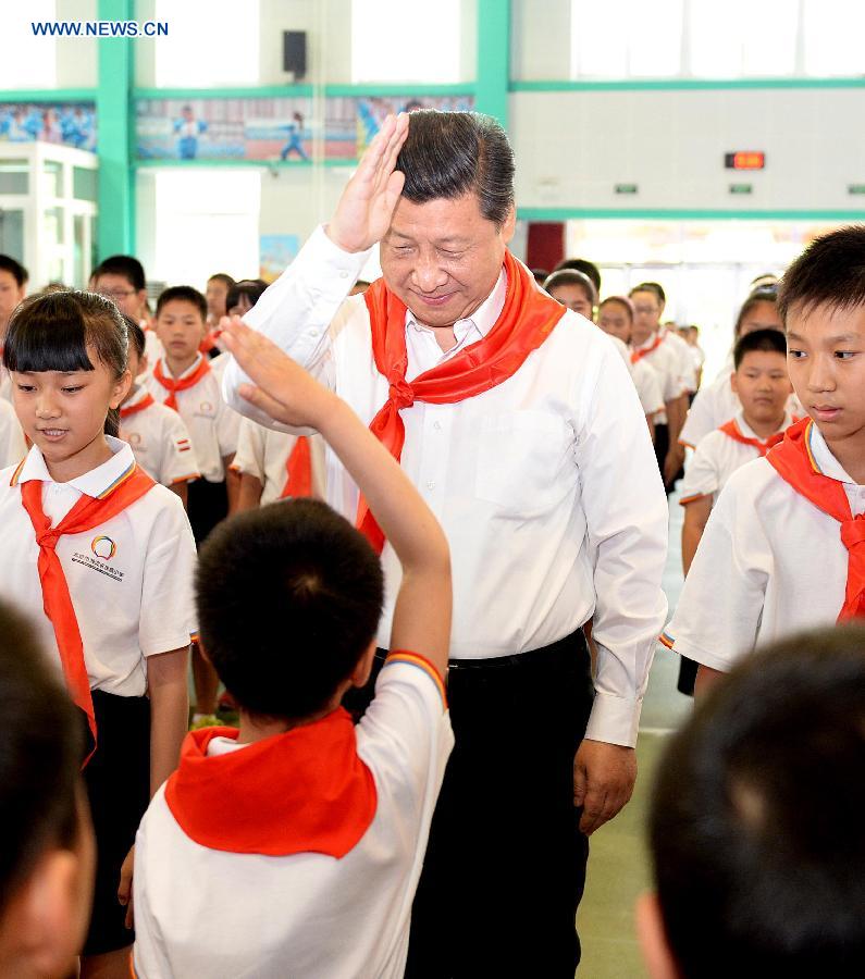 Chinese President Xi Jinping attends an initiation ceremony of Young Pioneers during his visit at Beijing Haidian National Primary School in Beijing, capital of China, May 30, 2014. Xi attended an activity to celebrate the upcoming International Children&apos;s Day at the primary school.