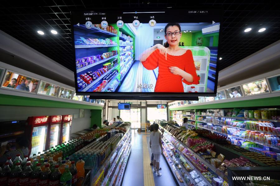 Shopping information in sign language is on screen at an accessible supermarket during its soft operation in Shenyang, capital of northeast China&apos;s Liaoning province, May 30, 2014. The market with barrier-free designs including Braille tags, blind tracks and free loans of wheelchairs, will officially open in June. All employees of the market are disabled people.