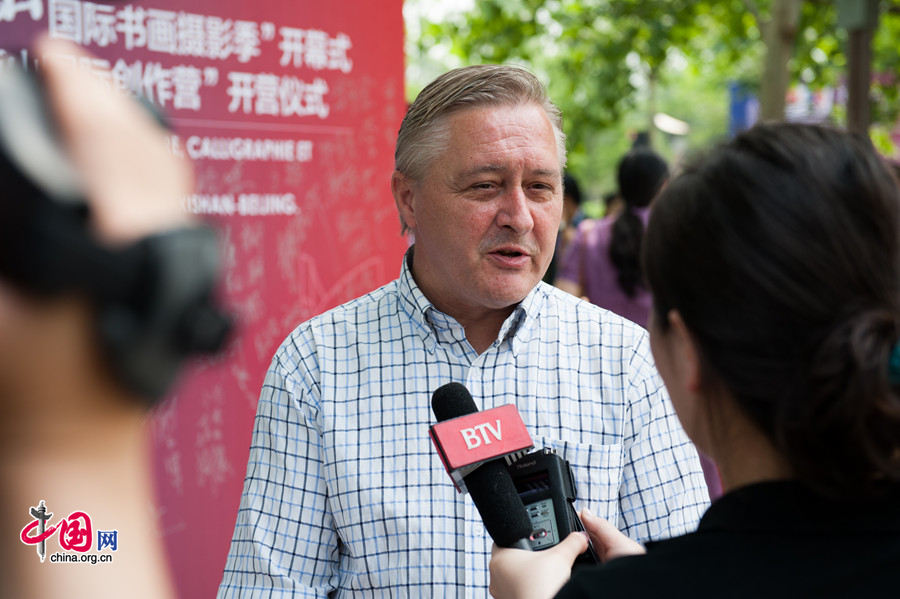 French photographer Philippe Bourgois takes questions from the press at the Opening Ceremony of Xishan International Season of Painting, Caligraphy and Photography held on Saturday, May 31 in the Chinese capital Beijing. [Photo by Chen Boyuan / China.org.cn]