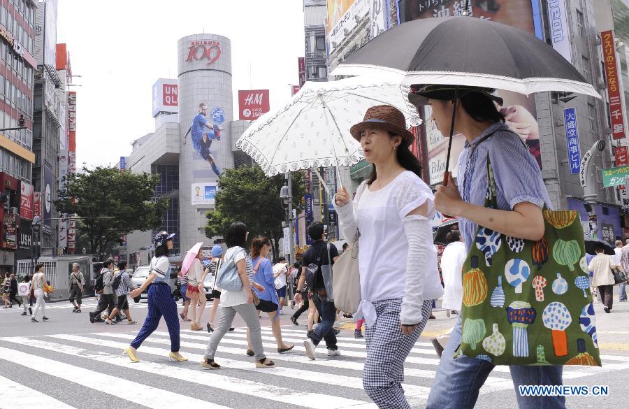 Tokyo, Japan. 6th Aug, 2014. Pedestrians walk under the hot