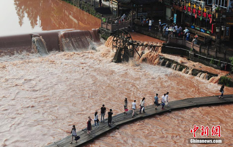 A scenic spot nearly submerged by river water in the Fenghuang Ancient Town, a famous tourist site in central China's Hunan province, attracts many visitors and photographers to the area on June 2, 2014. Recently, continuous rain has created a surge in river-water levels. [Photo: Chinanews.cn/Yang Huafeng] 