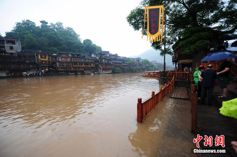 A scenic spot nearly submerged by river water in the Fenghuang Ancient Town, a famous tourist site in central China's Hunan province, attracts many visitors and photographers to the area on June 2, 2014. Recently, continuous rain has created a surge in river-water levels. [Photo: Chinanews.cn/Yang Huafeng] 