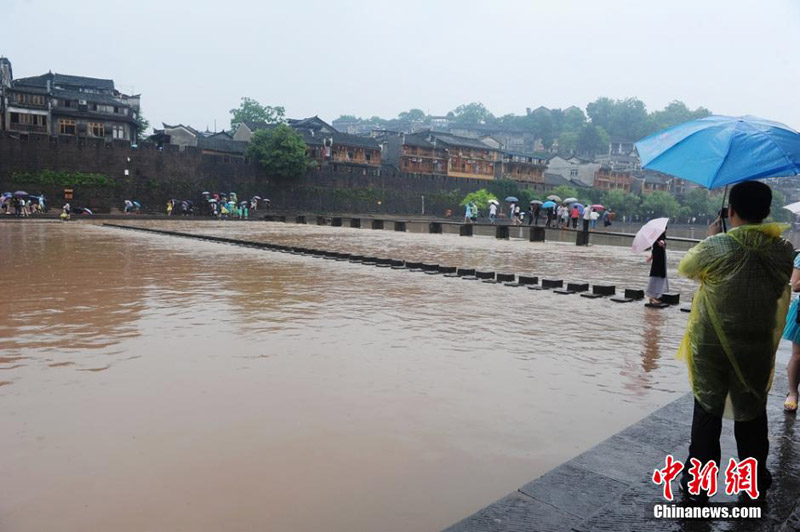 A scenic spot nearly submerged by river water in the Fenghuang Ancient Town, a famous tourist site in central China's Hunan province, attracts many visitors and photographers to the area on June 2, 2014. Recently, continuous rain has created a surge in river-water levels. [Photo: Chinanews.cn/Yang Huafeng] 