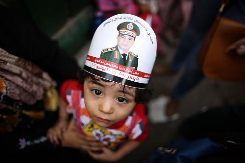 An Egyptian child with a portrait of ex-army chief Abdel Fattah al-Sisi on his head takes part in celebrations in Cairo's Tahrir Square on June 3, 2014 after Sisi won 96.9 percent of votes in the country's presidential election. [Xinhua photo]
