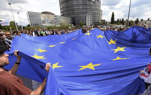 People hold a giant European Union flag as they take part in a demonstration against the French far-right party Front National (FN) following the vote for the European elections, on May 29, 2014 in front of the European Parliament in Strasbourg, eastern France. France suffered a political earthquake on May 25 as the Front National topped the polls in European elections with an unprecedented haul of one in every four votes cast. [Xinhua photo]