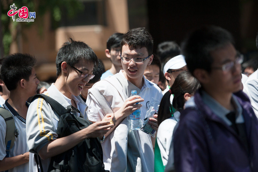 Students discuss with each other while wearing smile after finishing the Exam on Chinese, the first subject of the two-day national college entrance exam, on Saturday, June 6, 2016, at the Middle School Affiliated to Capital Normal Univeristy (CNU). Official statistics show a total of 9.39 million students are registered to take the two-day exam, a 3 percent increase than last year. [Photob by Chen Boyuan / China.org.cn]