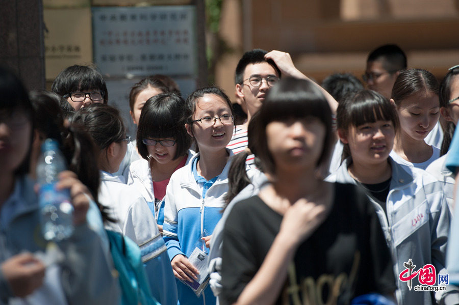 A student beams to her family members waiting outside the school gate at the Middle School Affiliated to Capital Normal Univeristy (CNU) on Saturday, June 6, 2014, after finishing the Exam on Chinese. Official statistics show a total of 9.39 million students are registered to take the two-day exam, a 3 percent increase than last year. [Photob by Chen Boyuan / China.org.cn]