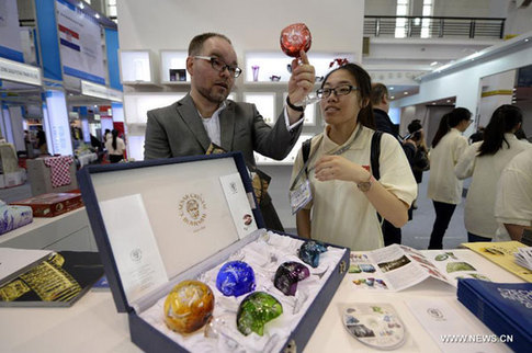 A Czech exhibitor introduces a crystal goblet to a visitor during the 2014 Central and Eastern European Countries' Products Fair (CEEC Fair) in Ningbo, east China's Zhejiang province, June 8, 2014. [Photo/Xinhua]