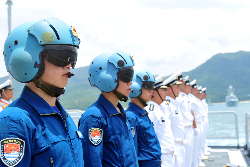 Pilots of shipboard helicopters stand on China's missile destroyer Haikou at a naval port in Sanya, south China's Hainan Province, June 9, 2014. The Chinese navy will participate in the Rim of the Pacific (RIMPAC) multinational naval exercises for the first time. A missile destroyer, a missile frigate, a supplier ship and a hospital ship of the Chinese navy left for the United States on Monday to attend the exercises. [Xinhua Photo]