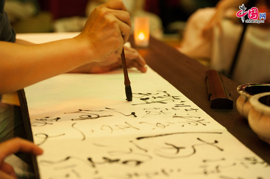 A calligrapher showcases writing Chinese characters with a brush pen on Thursday, June 12, 2014, part of a series of activities to commemorate China&apos;s 9th National Day of Cultural Heritage, which falls on June 14 each year. [Photo by Chen Boyuan / China.org.cn]