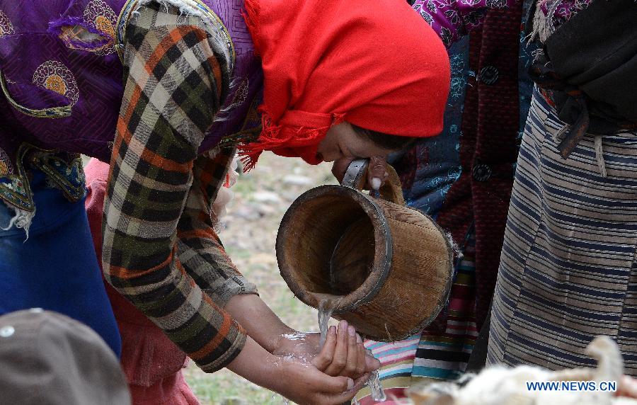 A local villager washes her hands before milking their sheep at Namco Township of Damxung County in Lhasa, capital of southwest China&apos;s Tibet Autonomous Region, June 20, 2014. Northern Tibet has entered its sheep-milking season in summer. Ewes that have given birth to lambs at the beginning of this year will be milked in this season. (Xinhua/Chogo)