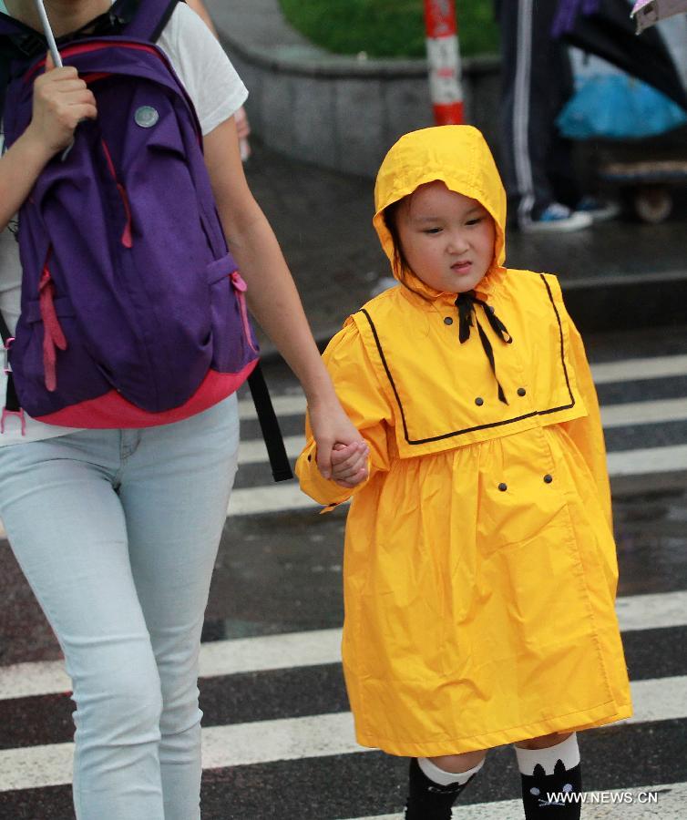 A little girl walks in a raincoat in east China's Shanghai Municipality, June 26, 2014. Parts of Shanghai received torrential rain Thursday. [Photo/Xinhua]