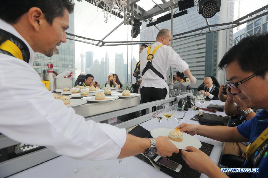 Diners enjoy their meals at a 22-seat restaurant lifted in the air in Lujiazui finance zone in Pudong of east China&apos;s Shanghai, June 27, 2014. A hotel in Shanghai launched a three-day service &apos;dinner in the sky&apos; on Friday. Diners were seated at a table suspended from a crane at the height of 50 meters. (Xinhua/Shen Chunchen)