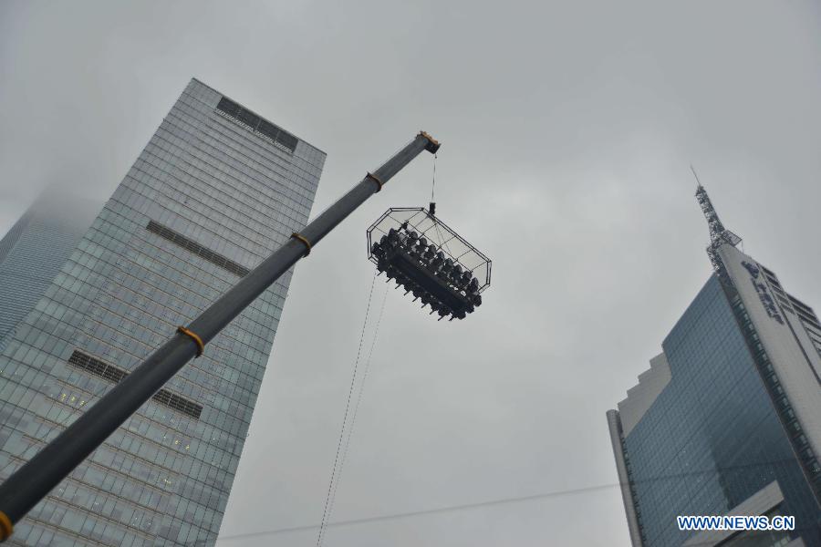 A 22-seat restaurant is lifted in the air in Lujiazui finance zone in Pudong of east China&apos;s Shanghai, June 27, 2014. A hotel in Shanghai launched a three-day service &apos;dinner in the sky&apos; on Friday. Diners were seated at a table suspended from a crane at the height of 50 meters. (Xinhua/Shen Chunchen)