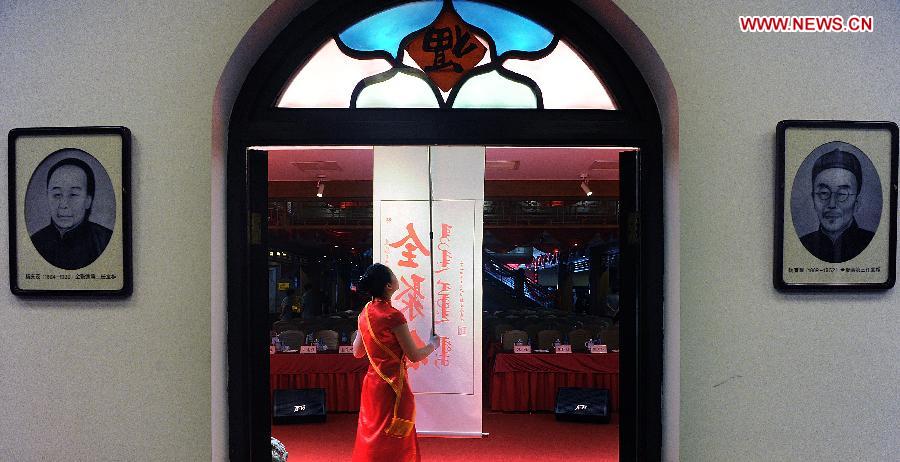 A waitress prepares for a ceremony for the 150th anniversary of Quanjude Beijing Roast Duck Restaurant at its Qianmen Branch in Beijing, capital of China, July 2, 2014. 