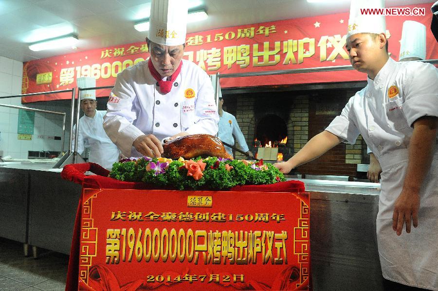 Head chef Zheng Zhiqiang places Quanjude&apos;s 196 millionth roast duck on a plate during a ceremony for the 150th anniversary of Quanjude Beijing Roast Duck Restaurant at its Qianmen Branch in Beijing, capital of China, July 2, 2014. 