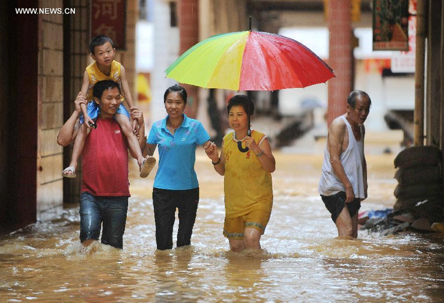 Residents are evacuated from flooded area in Mashan County, south China&apos;s Guangxi Zhuang Autonomous Region, July 5, 2014. A heavy rainfall hit the county on Saturday, affecting 4,2000 local people. 