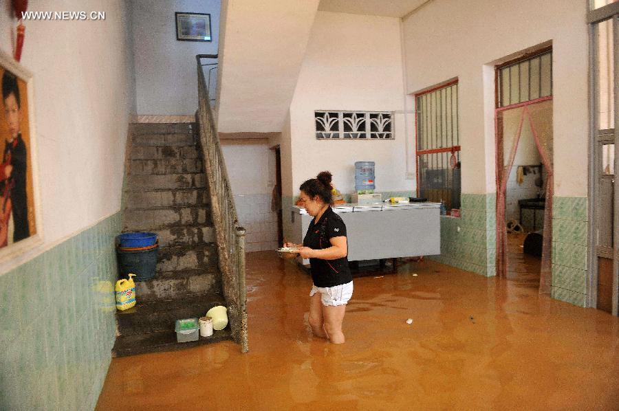 A woman prepares lunch in her flooded house in Mashan County, south China&apos;s Guangxi Zhuang Autonomous Region, July 5, 2014. A heavy rainfall hit the county on Saturday, affecting 4,2000 local people.
