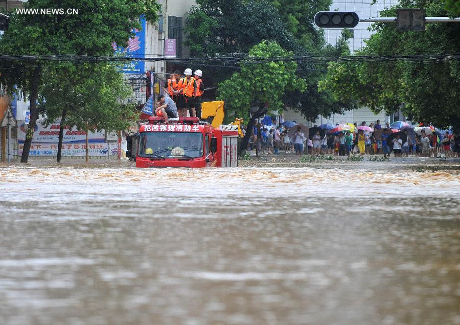 A fire engine is stranded on a flooded road in Mashan County, south China&apos;s Guangxi Zhuang Autonomous Region, July 5, 2014. A heavy rainfall hit the county on Saturday, affecting 4,2000 local people.