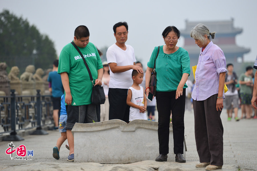 People visit the Marco Polo Bridge (aka. Lugouqiao in Chinese) on July 7, 2014, the 77th anniversary of the Marco Polo Bridge Incident (1937), which marks the full breakout of the Chinese people's war of resistance against Japanese invasion. [Photo by Chen Boyuan / China.org.cn]