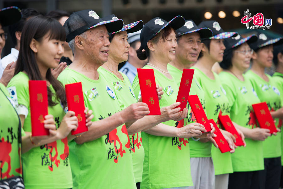 Volunteer traffic wardens line up to promote &apos;Zero Jaywalking&apos; on Tuesday, July 8, 2014 at a public place in east Beijing&apos;s Chaoyang District. The local Chaoyang district government initiated a campaign to ensure better road safety by eliminating pedestrian running red light, among other jaywalking activities. [Photo by Chen Boyuan / China.org.cn]